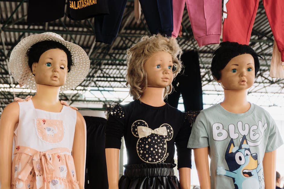 Three child mannequins showcasing trendy kids' fashion under a canopy at an outdoor market.