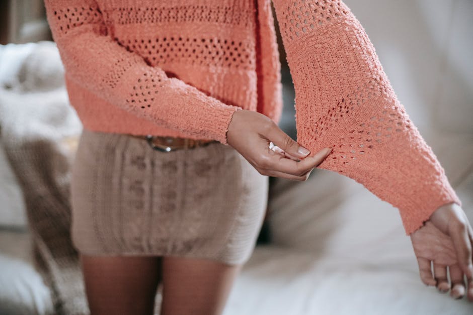 Detailed view of a woman's stylish crochet sweater and knit skirt combination.