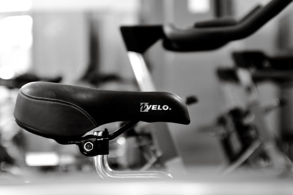 Detailed black and white shot of a gym bicycle saddle, highlighting fitness equipment aesthetics.