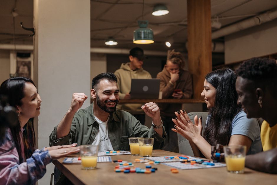 A group of friends playing a board game indoors, enjoying fun and laughter.